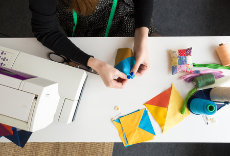 female hands holding color fabric pieces for patchwork quilt. tool kit for creation of a scrappy...