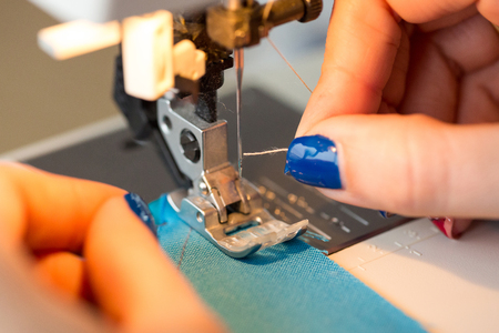 needlework and hand quilting in the workshop of a tailor - close-up on tailor fingers with a...