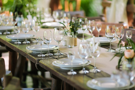 Glasses on the festive table setting. Wedding table decor concept. Table setting in classic style,...