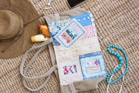 Set of summer items. Girl essentials with mobile phone and headphones, beads, hair brush, straw hat,...