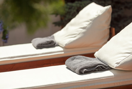 hotel rest, vacations and summer joy concept - closeup beautiful sun loungers with cushions and...