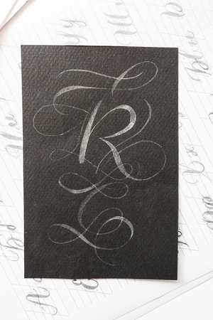 calligraphy, occasion, painting concept. on the dark black very textured paper there is big latin...
