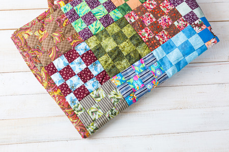 comfort, accessories, art, creation, style concept - original handiwork in asian traditions made of little textile squares in red, green and blue shades with such prints as flowers, leaves and stripsの写真素材