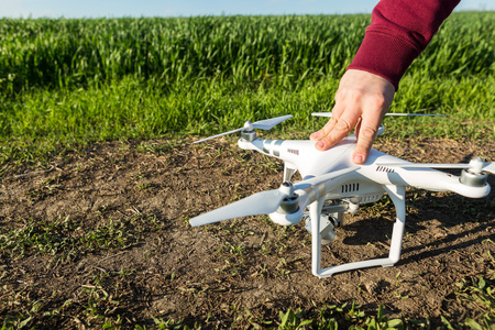 RUSSIA, ROSTOV-ON-DON - APRIL 20, 2017:- quadrocopter flight preparation on spring wheat field, male...