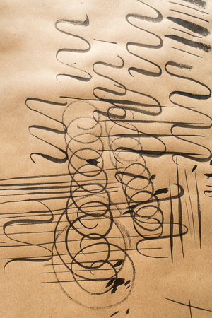 practice, education, drawing concept. on the piece of brown craft paper there are a lot of marks of sketching and warming up, different straight, swirl and curly linesの写真素材