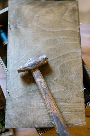 there is wooden box with small unclogged nails and big hammer for repairing and creating thingsの写真素材