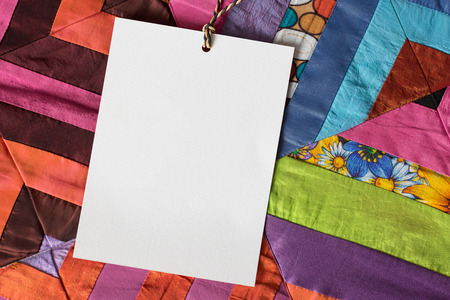 patchwork, greeting, handwork concept. close up of white very textured card on thin rope, it is...