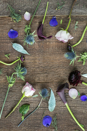 background, interior, nature concept. marvelous flowers with buds of different shapes and colores and cleaned stalks are placed on the wooden table and create circleの写真素材
