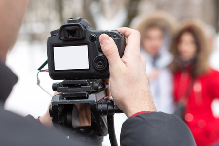 season, hobby, art work concept. close up of professional camera with blank screen in the arm of...