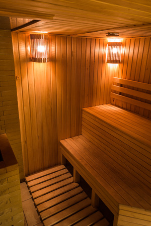 leisure time, spa, rest concept. there is peaceful atmosphere of steam bath, this place is decorated with lots of wood and wonderful soft light of orange and light red colouresの写真素材