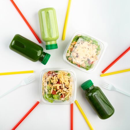 Business and food. A set of healthy food for a take-away working lunch. Green smoothies, and salads on a white background. The concept of delicious lunches.の写真素材