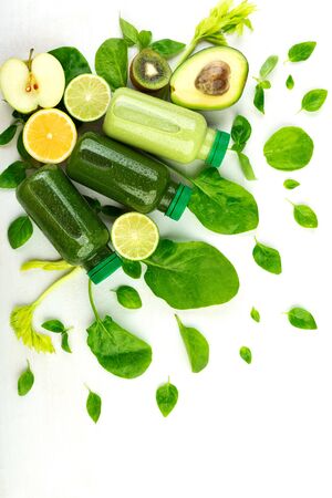 Vegetables, fruits and green detox mixtures in disposable bottles set against a white background. Template for step-by-step preparation of drinks and healthy meals at home.の写真素材