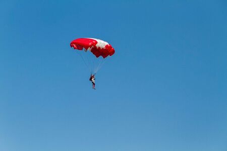 the sportsman lands to the ground with a red and white parachute. Copy pastre spaceの写真素材
