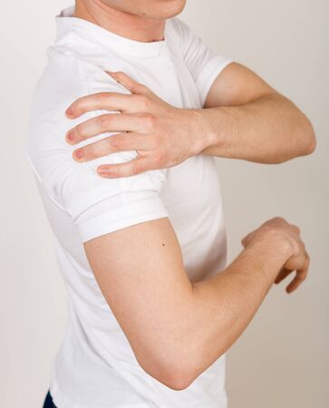 Crop of a man's body view on the side. Male rubbing his hand sick lecho. The concept of physical pain, body disorders. The harm of constant work with the computer, sedentary lifestyle.の写真素材