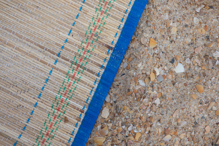 Bamboo mat on sand beach - background
