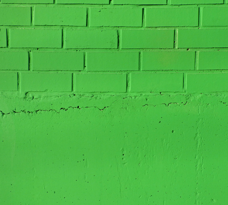 Bright green brick wall and a plaster texture. Closeup view of solid surface with regular structure. Industrial or construction background with place for textの写真素材