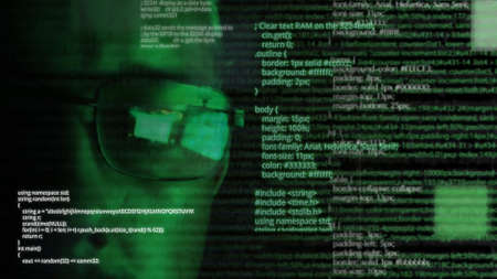 Programmer or hacker in glasses - software code reflecting in the glass and flying around