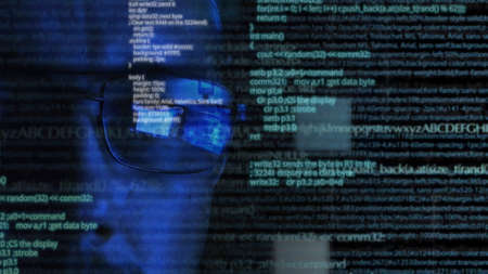 Programmer or hacker in glasses - software code reflecting in the glass and flying around