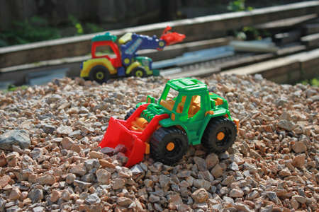 Toy tractors on a pile of rubble, kids game