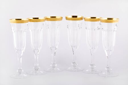 Stemware faceted glasses made of Czech glass with a Golden ornament isolated on a white background.の写真素材