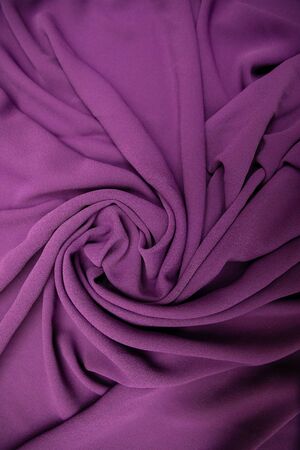 Purple fabric spread out on the table and slightly twisted. Materialの写真素材