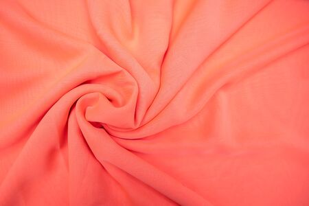 Light pink fabric spread out on the table and slightly twisted materialの写真素材