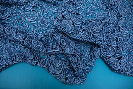 Blue patterns on top of blue fabric spread out on the table.の写真素材