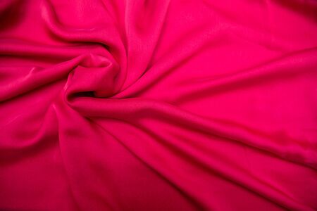 Red fabric spread out on the table and slightly twistedの写真素材