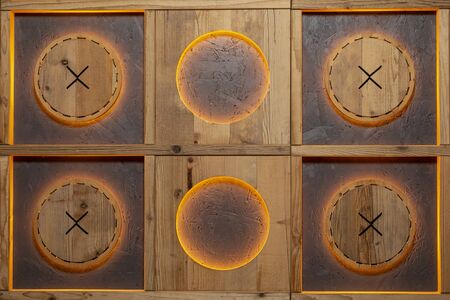 Decorative wall handmade  with orange lighting made of wood in the form of squares and circles in them.の写真素材