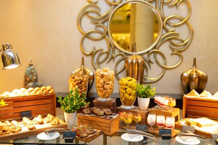 Various cookies on wooden boxes, in transparent glass vases, fruit salads, fruit yogurts in glass glasses, sandwichesの写真素材