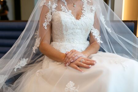 The bride sitting in a wedding dress with a veil.の写真素材