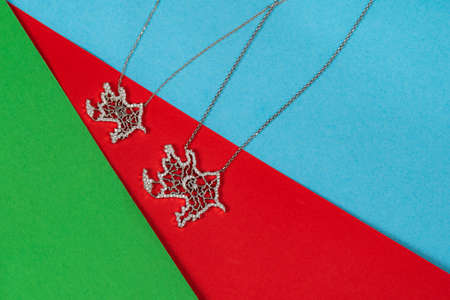 Big and small azerbaijan maps silver necklace on tricolor backgroundの写真素材