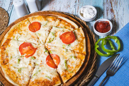 A freshly baked pizza Margherita with olive oil, tomatoes, mozzarellaの写真素材