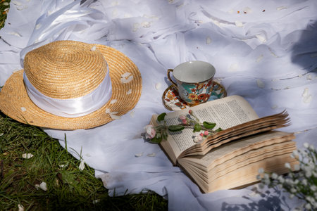Serene Picnic with Book, Straw Hat, and Tea Cup