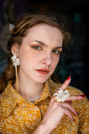 Woman Displaying Elegant Floral Jewelry Close-Upの写真素材