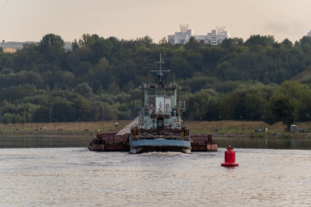 River Barge Transporting Goods on Scenic Waterwayの写真素材