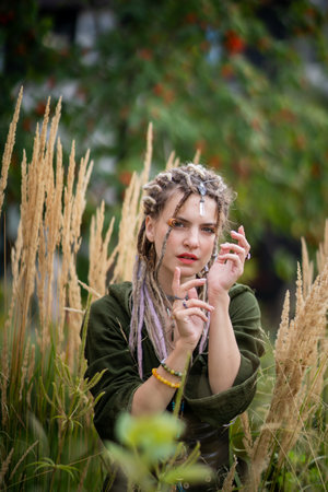 Woman Posing Thoughtfully in Nature with Dreadlocksの写真素材