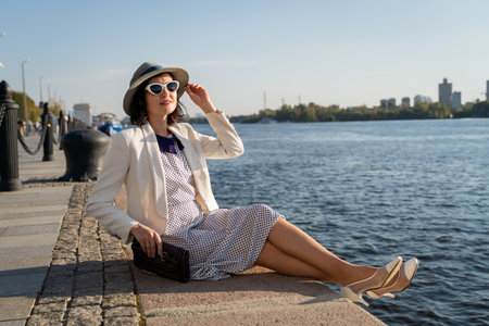 Woman Relaxing by River in Stylish Outfit and Sunglasses