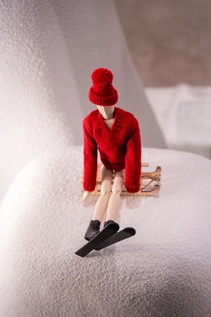 Wooden Mannequin Sledding on Snow in Red Winter Outfitの写真素材