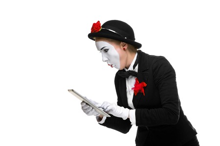 surprised business woman in the image mime holding tablet PC isolated on white backgroundの写真素材