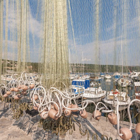 The small fishing harbor in Croatia. view of the boat through the networkの写真素材