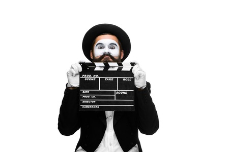 man in the image mime, dressed in black and white suit with movie board, isolated on a white backgroundの写真素材