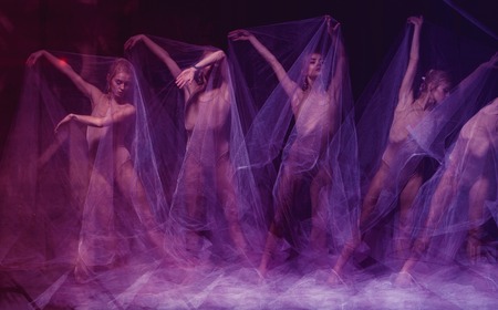 a sensual and emotional dance of beautiful ballerina through the veil on a dark backgroundの写真素材