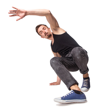 Break dancer doing an one handed handstand against a white background