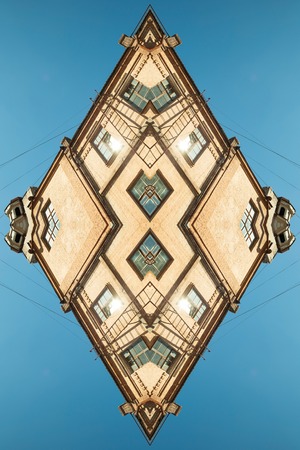 The beige abstrac geometric background of a pattern of windows in old factory building against a blue skyの写真素材