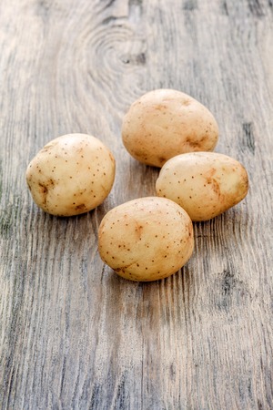 raw baby potatoes on rustic wooden backgroundの写真素材