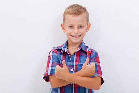 Portrait of happy boy showing thumbs up gesture,  over white backgroundの写真素材