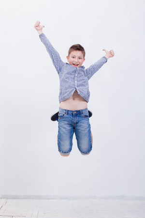 happy young boy jumping over a white backgroundの写真素材