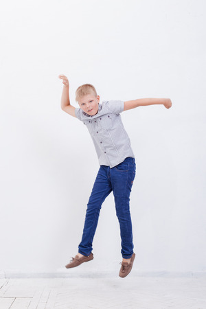 happy young boy jumping over a white backgroundの写真素材