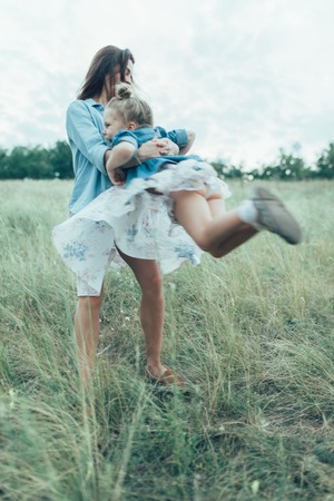 The young mother and daughter  on green grass backgroundの写真素材